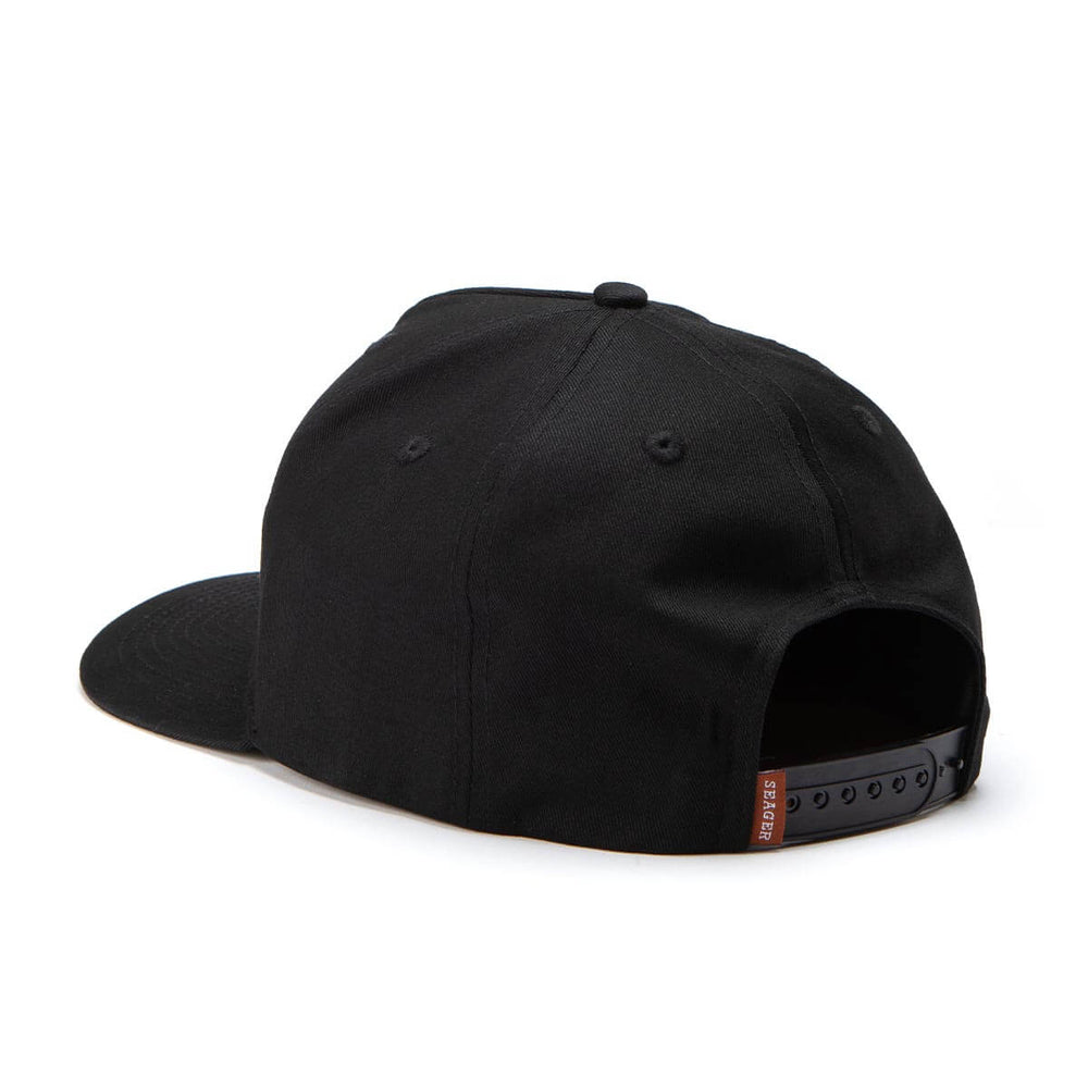 Black snapback hat from Seager with a brand logo on the side on a white background