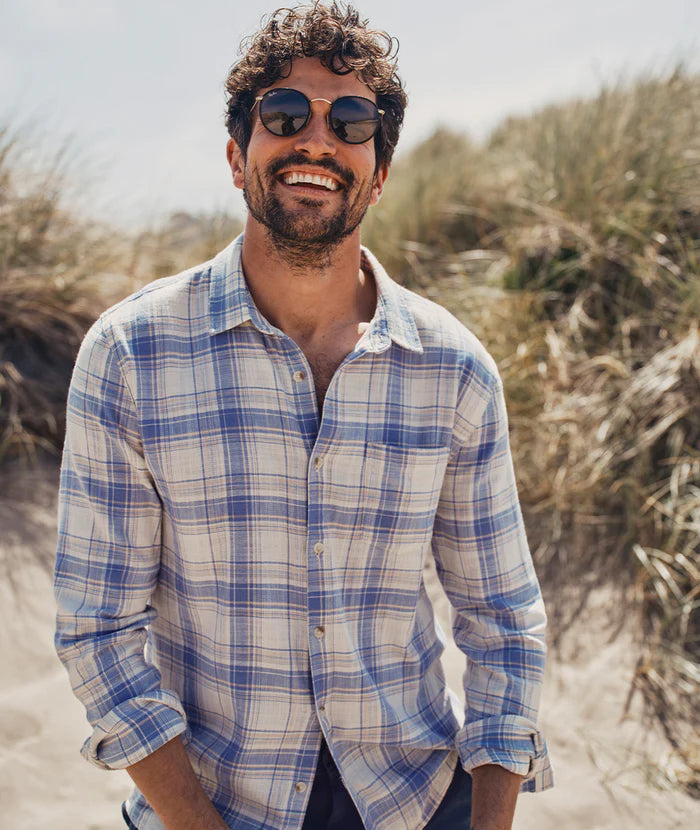 A man at the beach wearing the Indigo Cream Plaid Long Sleeve Classic Stretch Selvage Shirt by Marine Layer