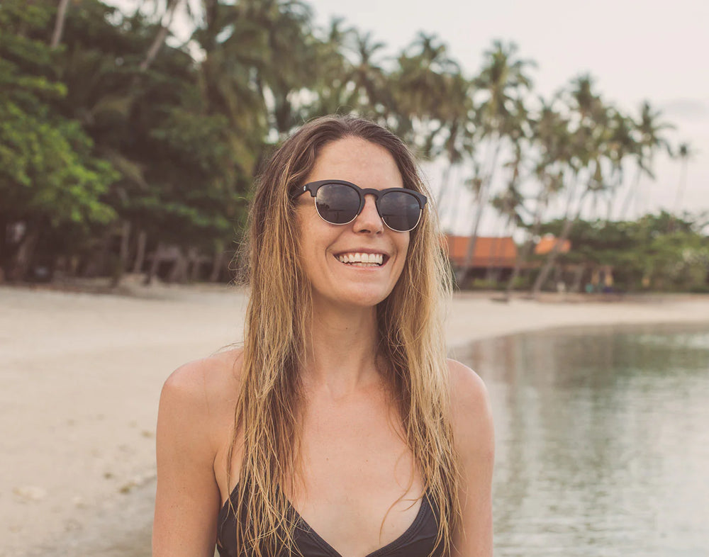 Woman at the beach wearing the Black Slate Avila Sunglasses by Sunski