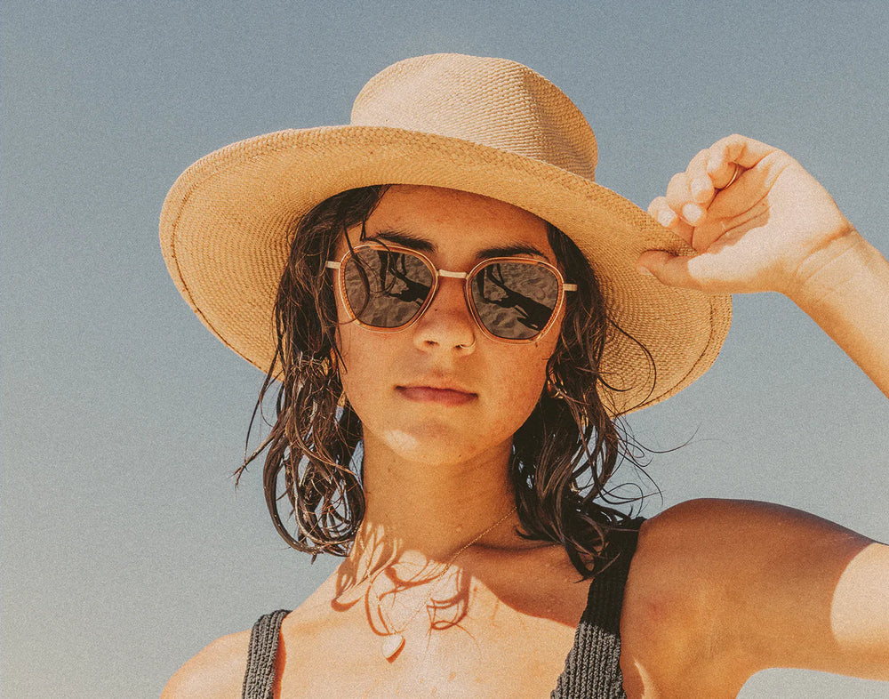 A woman wearing the Desert Amber Bernina Sunglasses by Sunsk