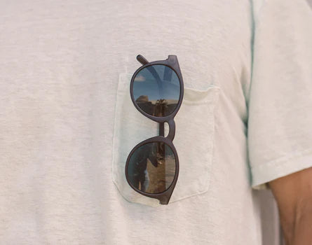 The Black Slate Dipsea Sunglasses by Sunski hanging out of a t-shirt pocket