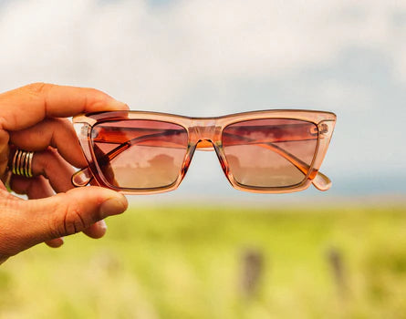 A person holding the Copper Terra Fade Fiorella Sunglasses by Sunski