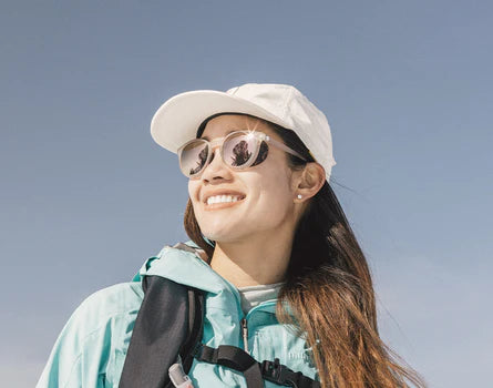 A woman wearing the Stone Alpenglow Tera Polarized Sunglasses by Sunski